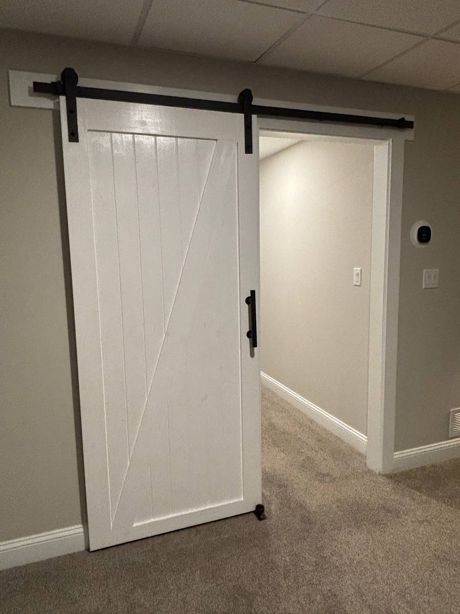 Painted wood barn door on a black metal track