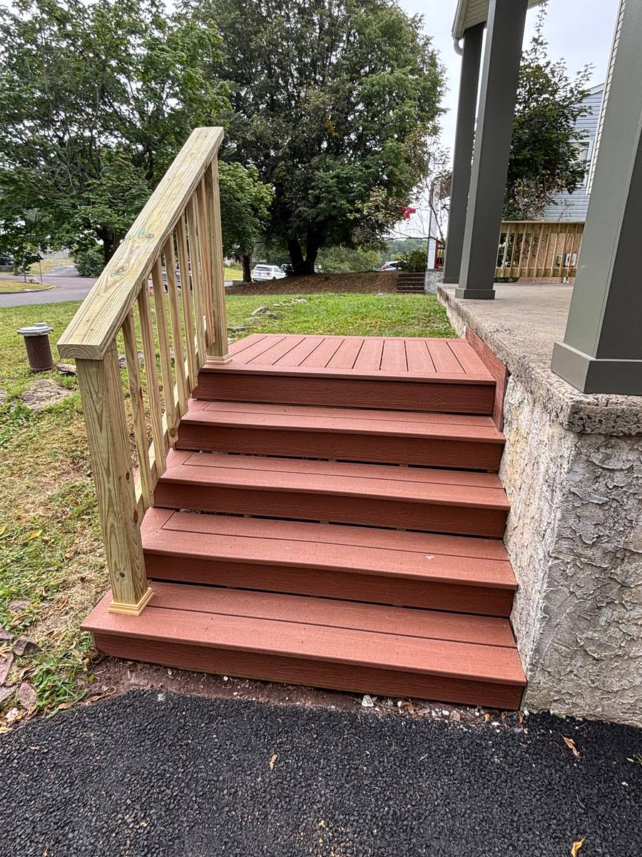 Composite deck stairs in redwood color with white railing