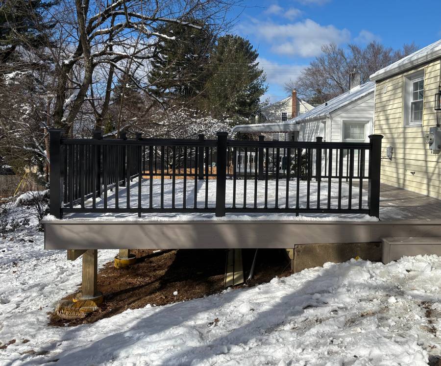 Composite deck with white vinyl railing in winter