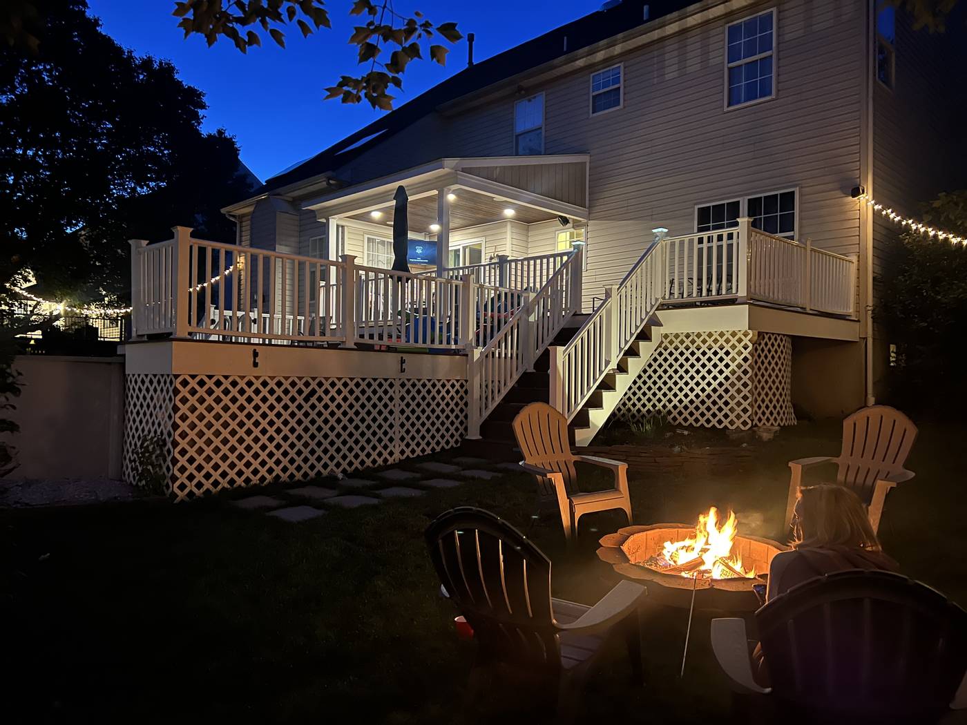A custom composite deck at dusk with a fire pit, built by Canyon Creek Construction
