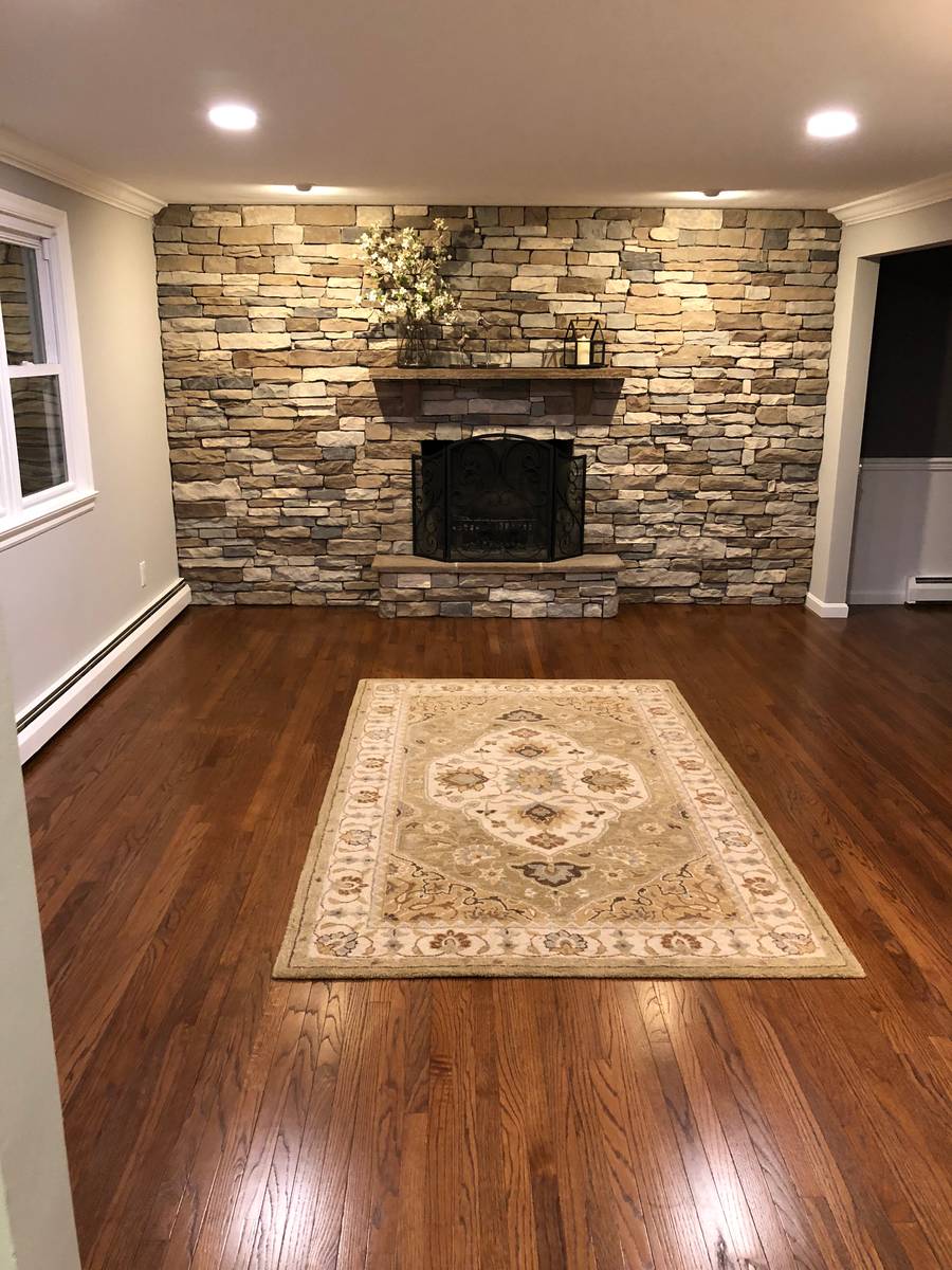 Finished living room with stone fireplace and built-ins